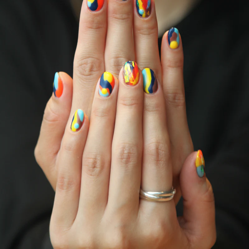 Bunt bemalte Fingernägel mit Farbklecksen