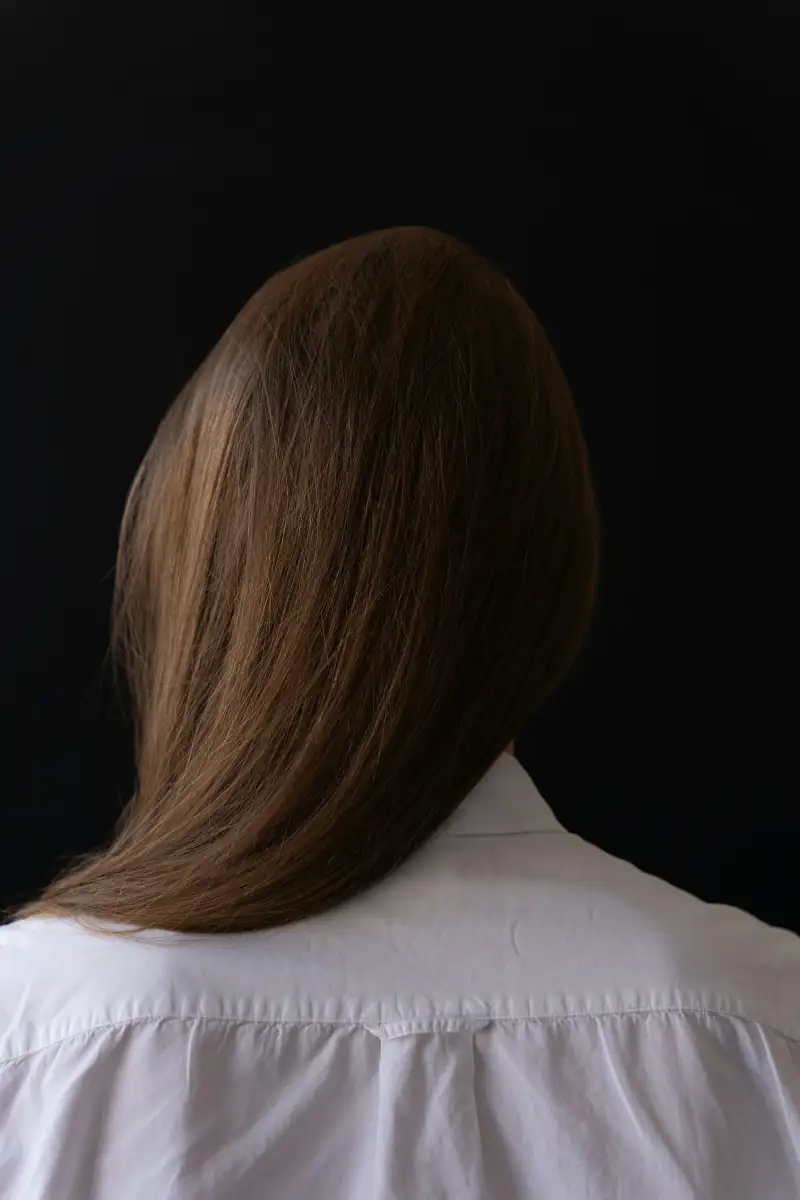 Glattes, glänzendes braunes Haar vor schwarzem Grund