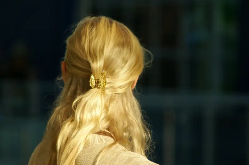 Goldblondes, gewelltes Haar, halb hochgesteckt mit einer Spange